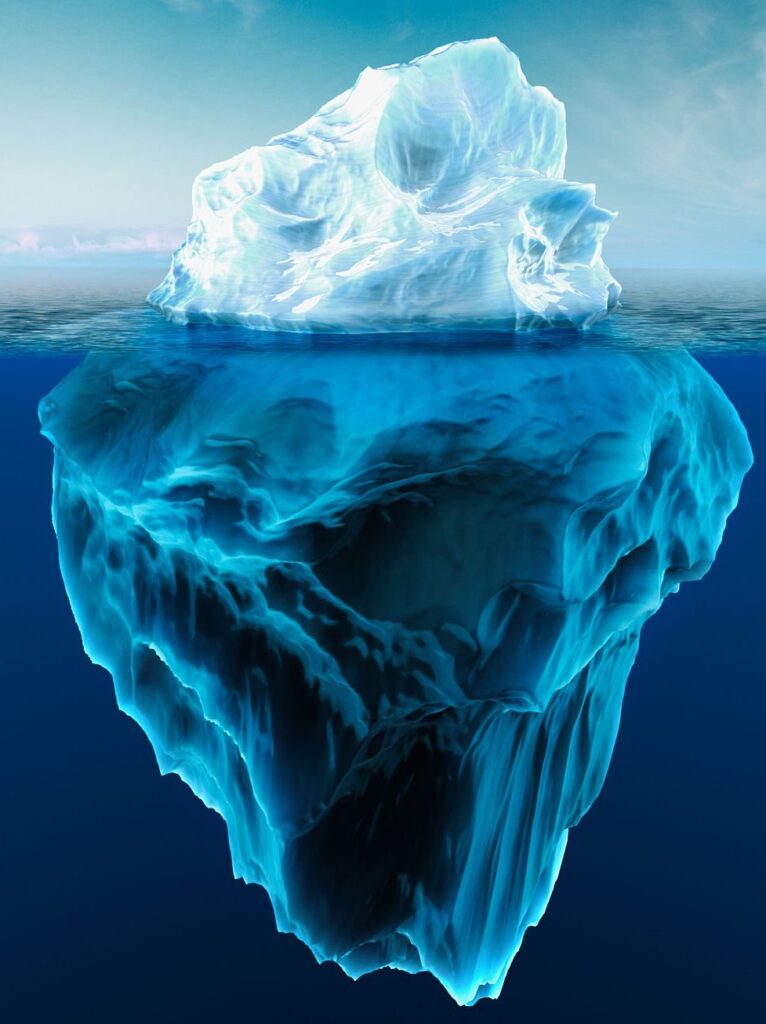 An iceberg with a small tip above the waterline and a large mass hidden below the surface.