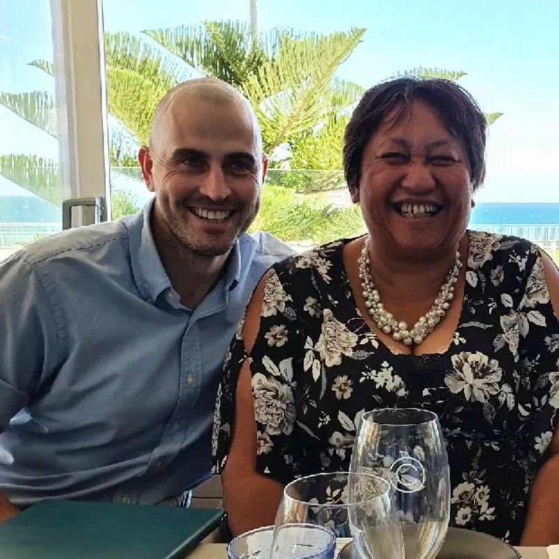 Two IRP team members smiling together at a table by the ocean.